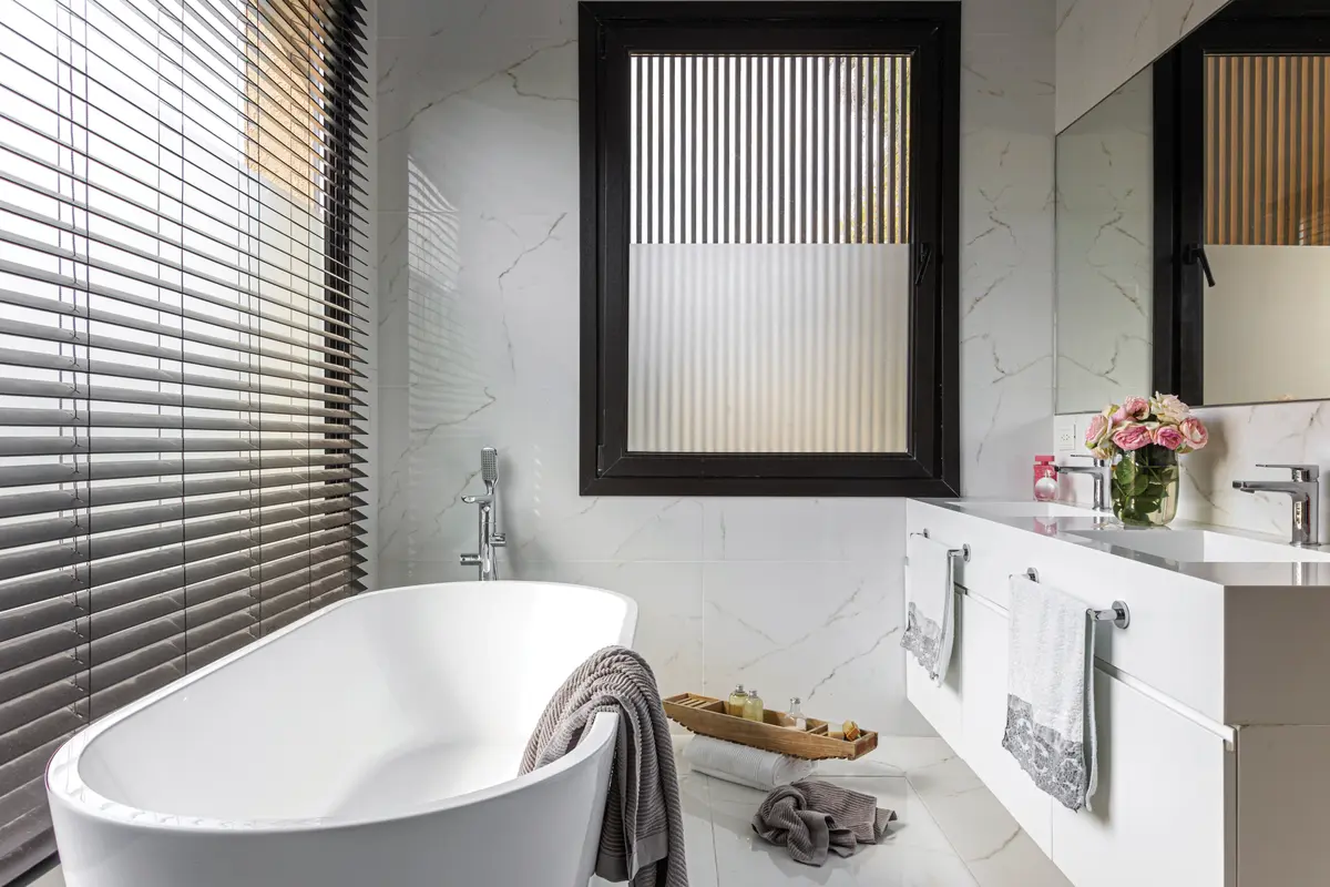 Banheiro moderno com banheira de imersão e detalhes em mármore — projeto Casa Bosque Chico, por Mazzinghi Sanchez, em Garin